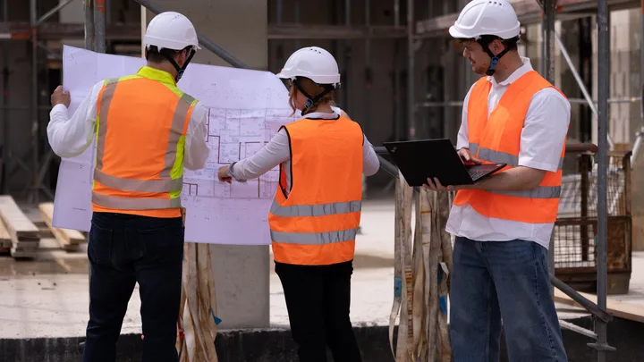 Site management reviewing the construction plans on site